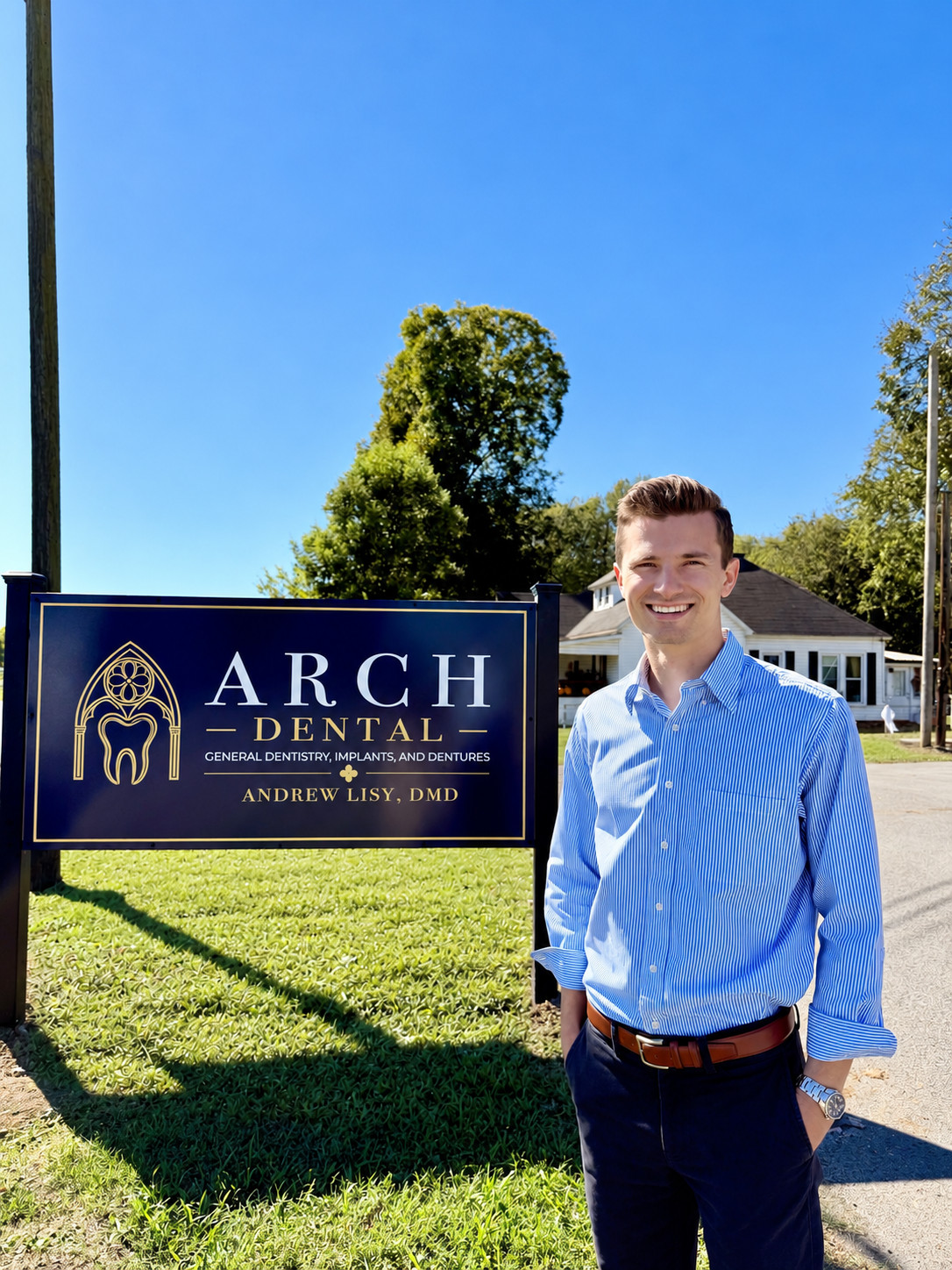 Dr. Andrew Lisy, DMD, standing beside the Arch Dental sign in South Pittsburg, TN